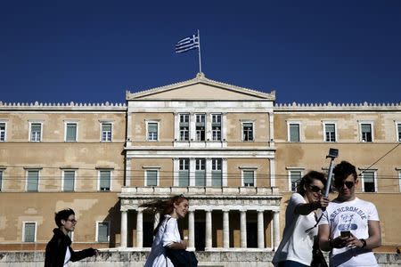 People walk past the parliament building in central Athens April 6, 2015. REUTERS/Alkis Konstantinidis