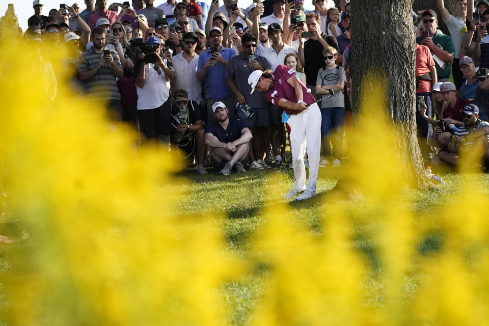 Cameron Smith hits his approach shot to the 18th green from the rough and next to a tree during the final round of the LIV Golf Invitational-Chicago tournament Sunday, Sept. 18, 2022, in Sugar Hill, Ill. (AP Photo/Charles Rex Arbogast)