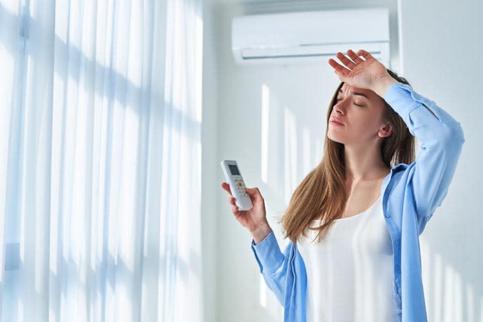 mujer utilizando el aire acondicionado