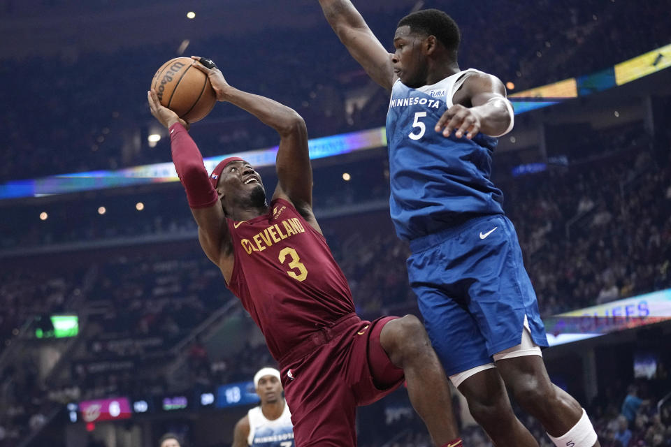 Minnesota Timberwolves guard Anthony Edwards (5) defends against Cleveland Cavaliers guard Caris LeVert (3) during the first half of an NBA basketball game Friday, March 8, 2024, in Cleveland. (AP Photo/Sue Ogrocki)