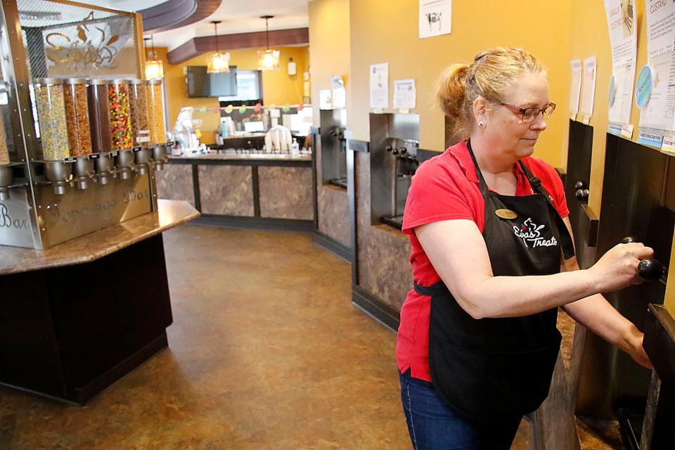 Nancy Pauly, owner of Eva's Treats dispenses frozen yogurt Friday, March 25, 2022. TOM E. PUSKAR/TIMES-GAZETTE.COM