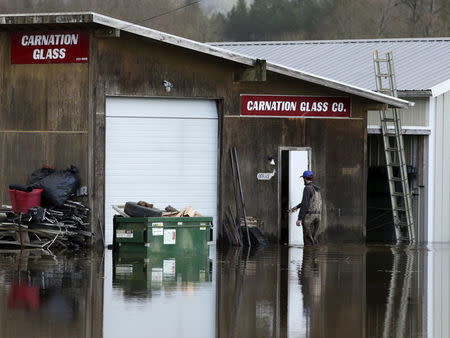 A man enters a flooded structure at the Carnation Glass Company as flood waters of the Snoqualmie River are pictured off State Route 203 during a storm in Carnation, Washington December 9, 2015. REUTERS/Jason Redmond