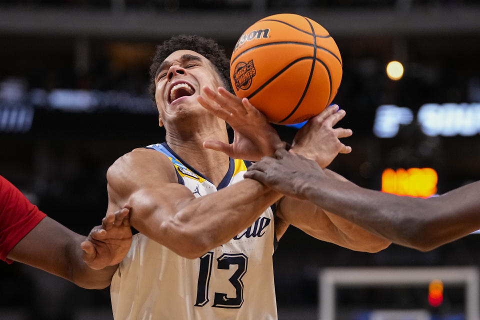 Marquette's Oso Ighodaro loses the ball while being pressured by North Carolina State's DJ Burns Jr., left, and Mohamed Diarra, right, during the second half of a Sweet 16 college basketball game in the NCAA Tournament in Dallas, Friday, March 29, 2024. (AP Photo/Tony Gutierrez)