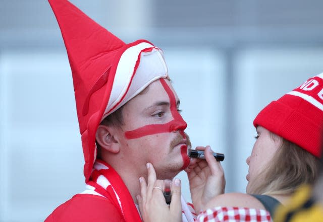 A fan has his face painted with the England flag