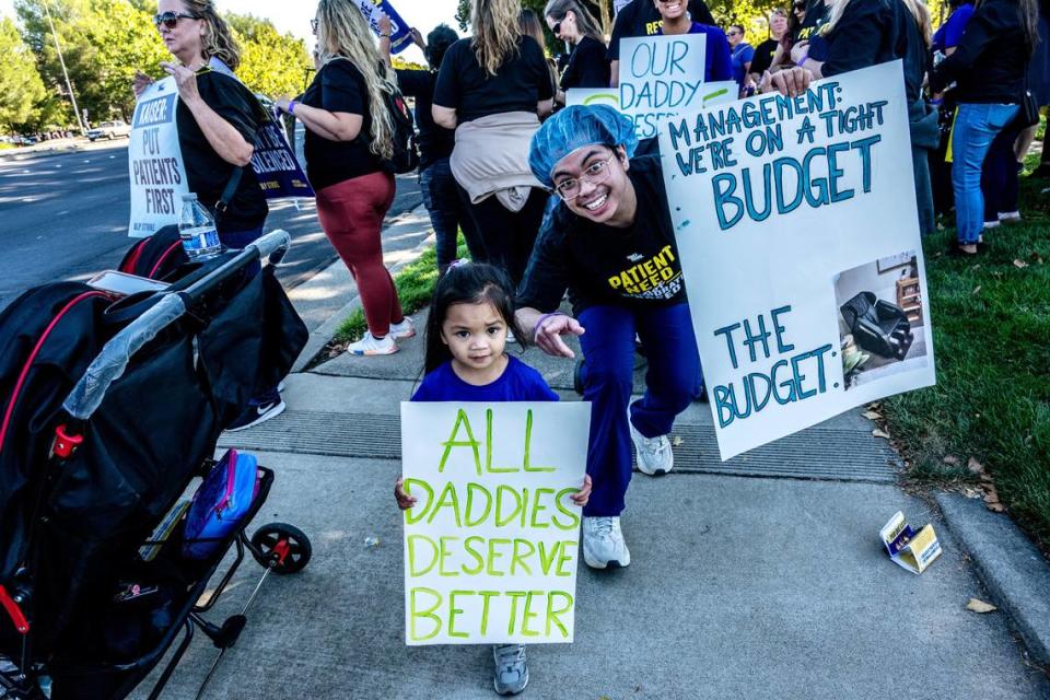 RJ Monteagudo, right, a sterile processing technician at Kaiser Permanente Roseville Medical Center, was joined by daughter Ria, 4, on the strike line with other health care workers on Wednesday, Oct. 4, 2023, in Roseville.