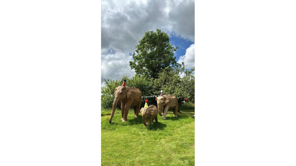 A photo of elephant statues wearing party hats