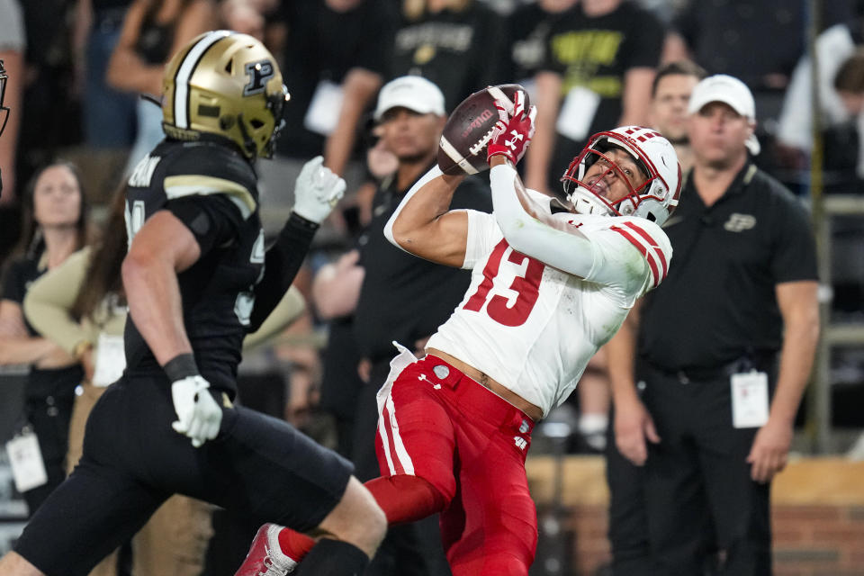 Wisconsin wide receiver Chimere Dike (13) makes a catch in front of Purdue defensive back Dillon Thieneman (31) during the second half of an NCAA college football game in West Lafayette, Ind., Friday, Sept. 22, 2023. (AP Photo/Michael Conroy)