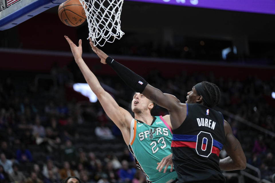 San Antonio Spurs forward Zach Collins (23) drives on Detroit Pistons center Jalen Duren (0) in the second half of an NBA basketball game in Detroit, Friday, Feb. 10, 2023. (AP Photo/Paul Sancya)