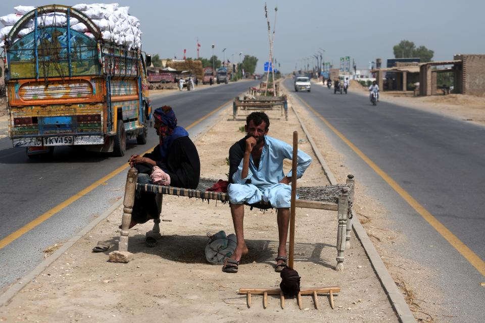 Many labourers and families place their charpoys on the divider on two-way roads so that gusts of wind from passing vehicles offer them some respite, even as they are forced to breathe toxic fumes from car emissions, in Jacobabad, Pakistan.