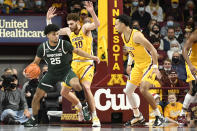 Michigan State guard Malik Hall (25) tries to drive past Minnesota forward Jamison Battle (10) as guard Payton Willis watches during the first half an NCAA college basketball game Wednesday, Dec. 8, 2021, in Minneapolis. (AP Photo/Craig Lassig)