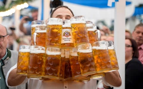 Oliver Struempfel competes during his world record attempt, carrying 27 beer mugs at the traditional festival Gillamoos in Abensberg - Credit: AP