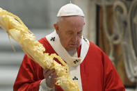 Pope Francis holds a palm branch as he celebrates Palm Sunday Mass behind closed doors in St. Peter's Basilica, at the Vatican, Sunday, April 5, 2020, during the lockdown aimed at curbing the spread of the COVID-19 infection, caused by the novel coronavirus. (AP Photo/pool/Alberto Pizzoli)