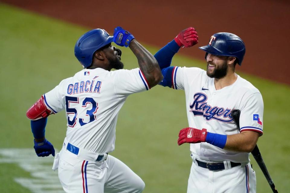 Texas Rangers’ Adolis Garcia (53) and Joey Gallo, right, celebrate Garcia’s solo home run in the first inning of a baseball game against the Oakland Athletics in Arlington, Texas, Saturday, July 10, 2021. (AP Photo/Tony Gutierrez)