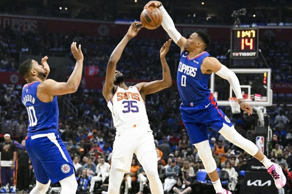 Clippers guard Russell Westbrook grabs the ball in front of Phoenix Suns forward Kevin Durant.