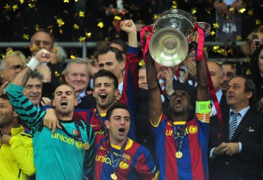 Barcelona's Eric Abidal (R) celebrates with the trophy at the end of the UEFA Champions League final match FC Barcelona vs Manchester United, on May 28, at Wembley stadium in London. Barcelona won 3-1