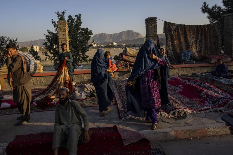 FILE - In this Wednesday, Sept. 15, 2021 file photo, Afghan women walk through a second-hand market where many families sold their belongings before leaving the country or due to financial struggle, in Kabul, Afghanistan. A month after the fall of Kabul, the question of how the world will get aid to citizens without enriching Afghanistan's Taliban rulers is haunting the country. (AP Photo/Bernat Armangue, File)