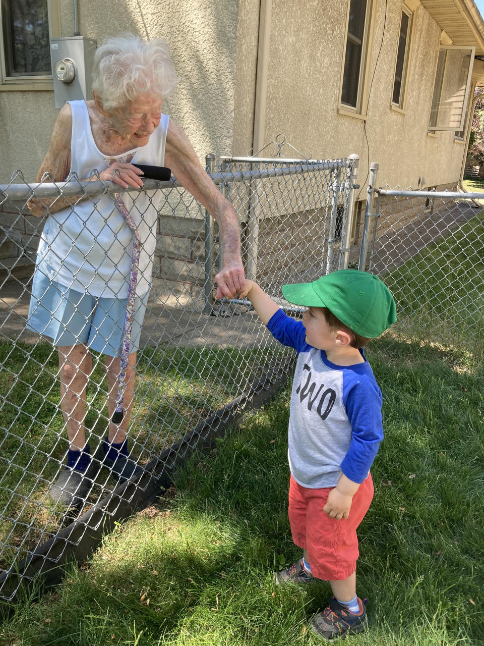 Mary O'Neill and Benjamin Olson have a chat by the fence that separates their homes.  (Sarah Olson)