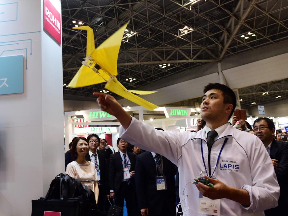 An employee of Japanese electronics parts maker Rohm demonstrates remote-controlled flying paper crane "Origami."