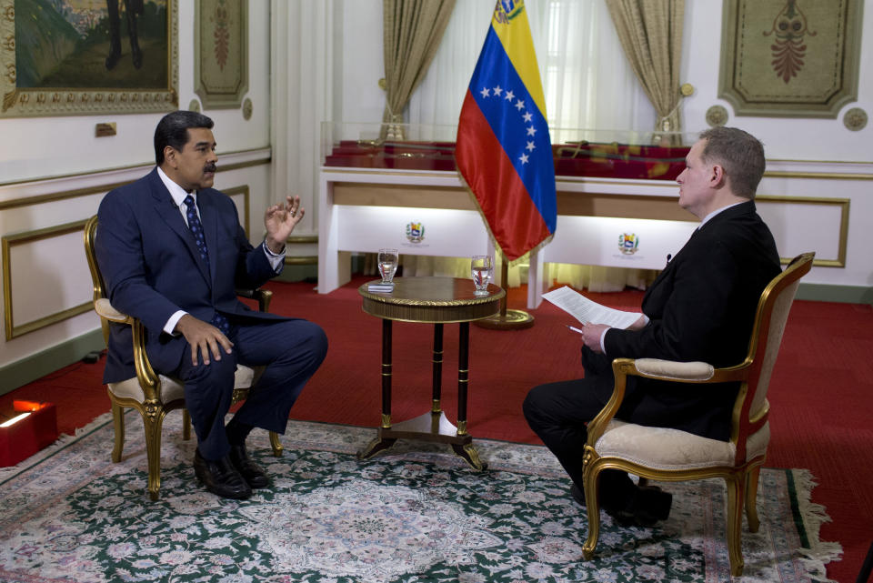 Venezuela's President Nicolas Maduro, left, speaks during an interview with Associated Press Vice President of International News, Ian Phillips, at Miraflores presidential palace in Caracas, Venezuela, Thursday, Feb. 14, 2019. Even while criticizing Donald Trump's confrontational stance toward his socialist government, Maduro said he holds out hope of meeting the U.S. president to resolve an impasse over his recognition of opponent Juan Guaido as Venezuela's rightful leader. (AP Photo/Ariana Cubillos)