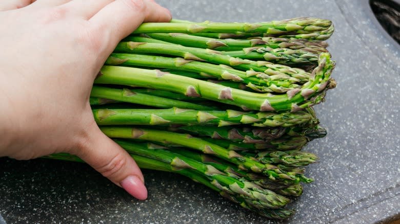 hand on bundle of asparagus