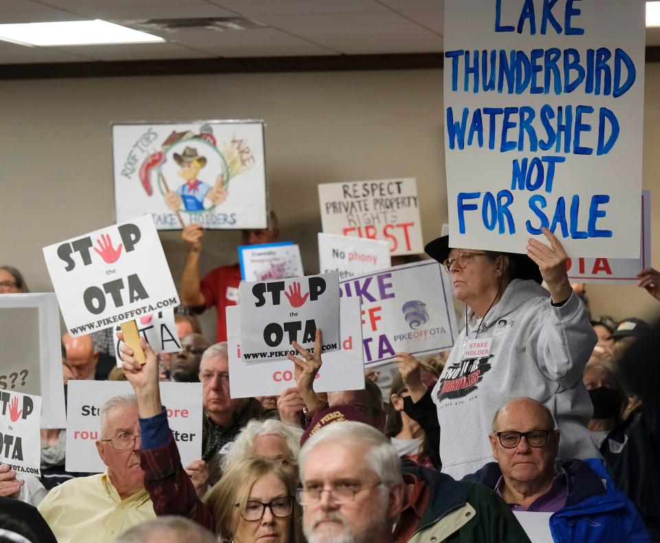 Turnpike protesters hold signs Tuesday, Jan. 3, 2023, during a meeting of the Oklahoma Turnpike Authority at the Oklahoma State Department of Transportation building.