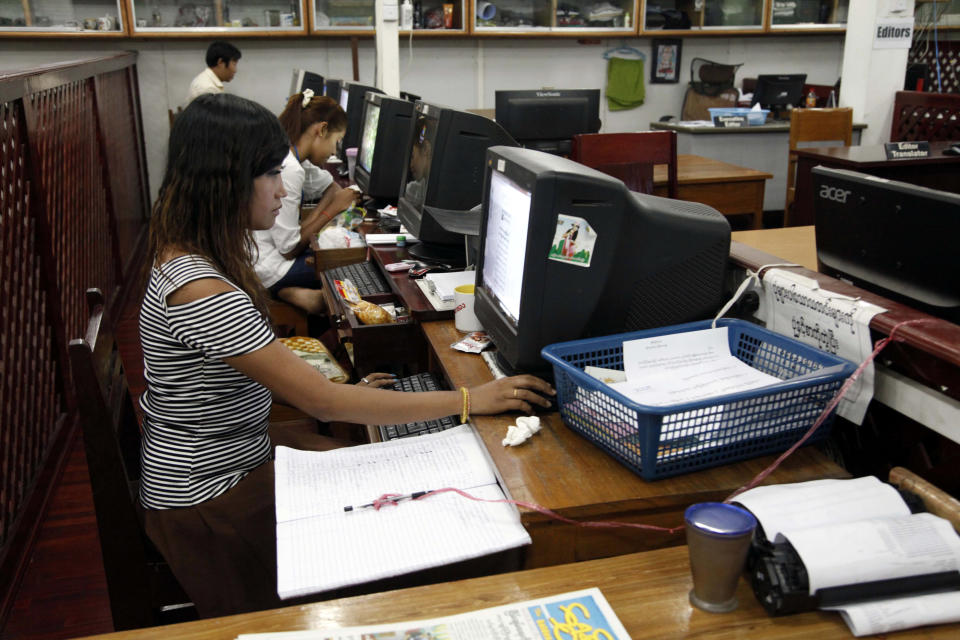 In this photo taken on March 11, 2014, staff members of “The Golden Fresh Land Daily” newspaper work at their newsroom in Yangon, Myanmar. One year after publishers and editors took advantage of a decision by the country's nominally civilian government to lift a half-century-old ban on private dailies, the feeling of euphoria is fading. The struggle to compete with state-owned papers for advertisers and circulation have made it impossible for many to forge on. Golden Fresh Land, published its last edition Wednesday, March 12. It is the first well-known private daily to fold, but 11 others that are still publishing also appear to be struggling.(AP Photo/Khin Maung Win)