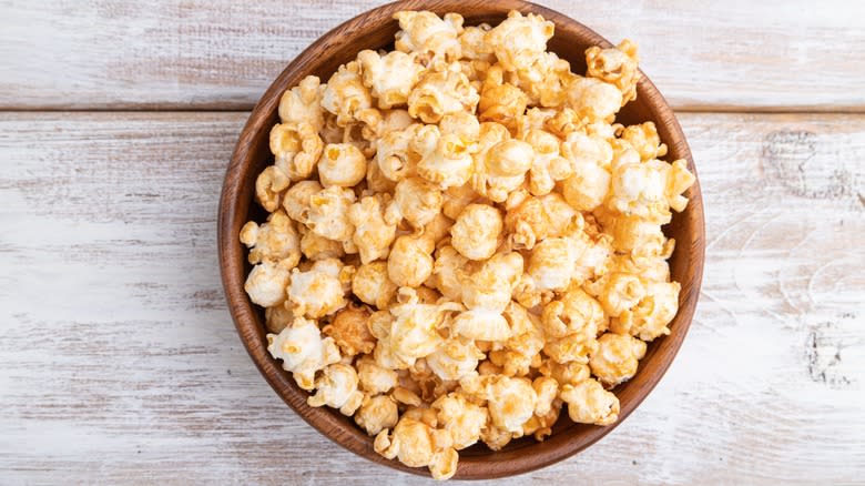 Popcorn in bowl on wooden table