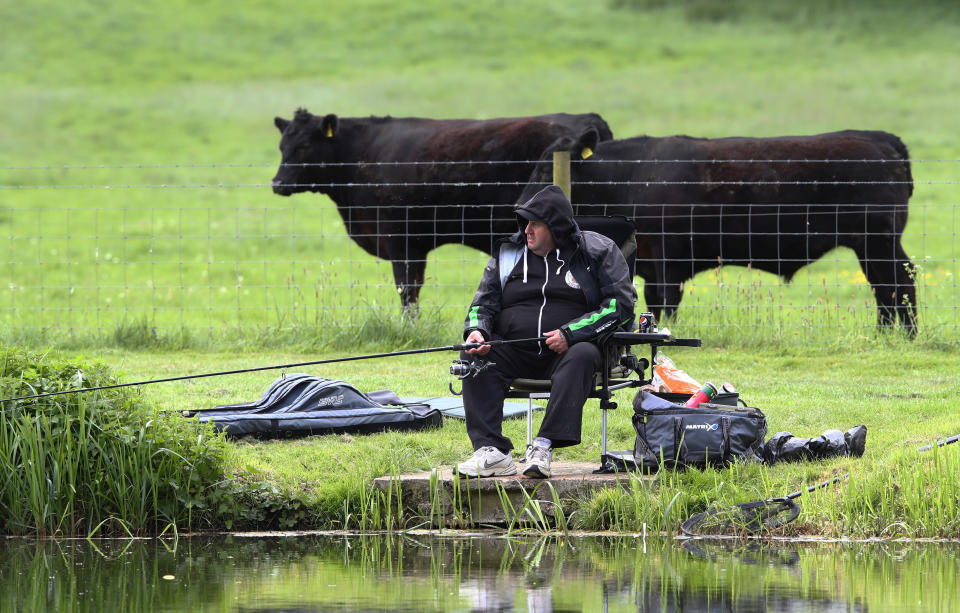 A man is seen fishing at Castle Ashby lakes in Northamptonshire.