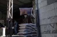 An employee carries a sack of rice imported from the United States inside a Shodecosa industrial park warehouse, in Port-au-Prince, Haiti, Wednesday, Sept. 29, 2021. Shodecosa is the country's largest industrial park, which warehouses 93 percent of the nation’s imported food. (AP Photo/Rodrigo Abd)