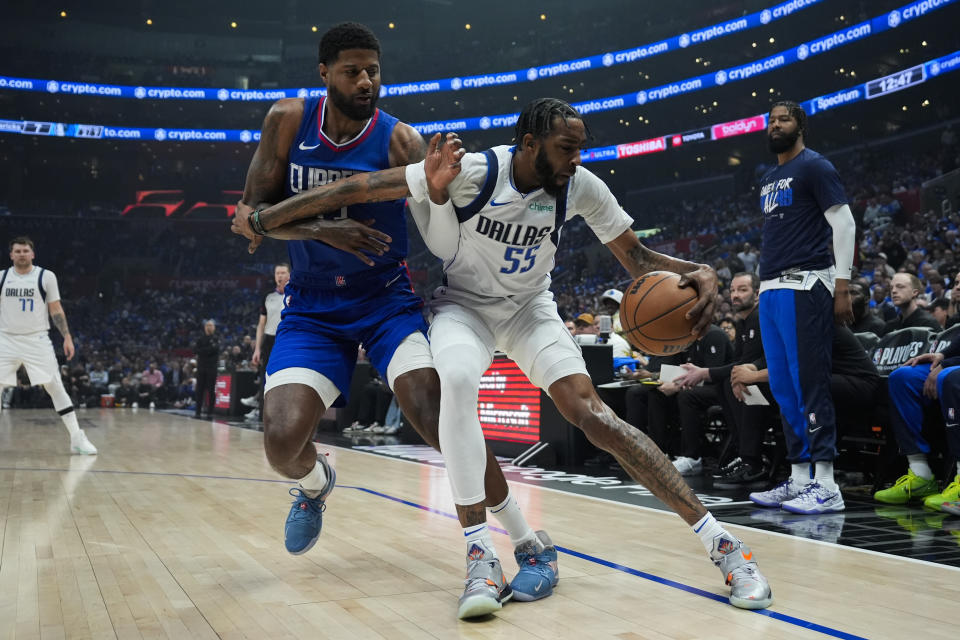 LA Clippers forward Paul George (13) defends against Dallas Mavericks forward Derrick Jones Jr. (55) during the first half of Game 1 of an NBA basketball first-round playoff series in Los Angeles, Sunday, April 21, 2024. (AP Photo/Ashley Landis)