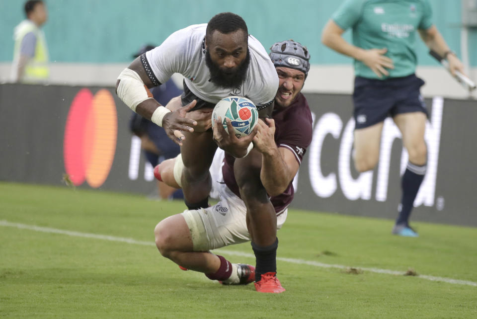 Fiji's Semi Radradra dives in the tackle of Georgia's Beka Gorgadze to score a try during the Rugby World Cup Pool D game at Hanazono Rugby Stadium between Georgia and Fiji in Osaka, Japan, Thursday, Oct. 3, 2019. (AP Photo/Jae C. Hong)