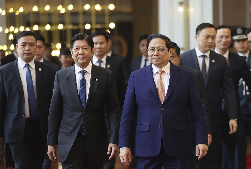 Philippine President Ferdinand Marcos Jr., front left, and Vietnamese Prime Minister Pham Minh Chinh, front right, walk to a meeting in Hanoi, Vietnam Tuesday, Jan. 30, 2024. Marcos is on a visit to Hanoi to boost the bilateral relation with the fellow Southeast Asian nation. (Duong Van Giang/VNA via AP)