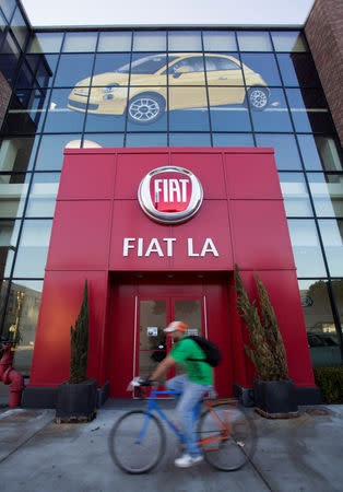 A person bikes past the entrance to a Fiat car dealership at Motor Village in Los Angeles, California October 13, 2014. REUTERS/Mario Anzuoni/