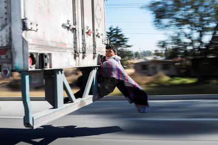Migrant Javier Gomez, from Honduras, takes a lift in the back of a truck during his journey towards the United States, in Mexico City, Mexico, January 31, 2019. REUTERS/Alexandre Meneghini