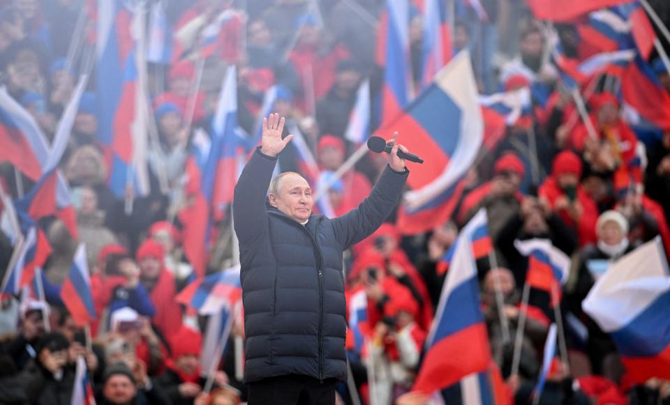 Russian President Vladimir Putin waves during a concert marking the eighth anniversary of Russia's annexation of Crimea at Luzhniki Stadium in Moscow, Russia March 18, 2022.