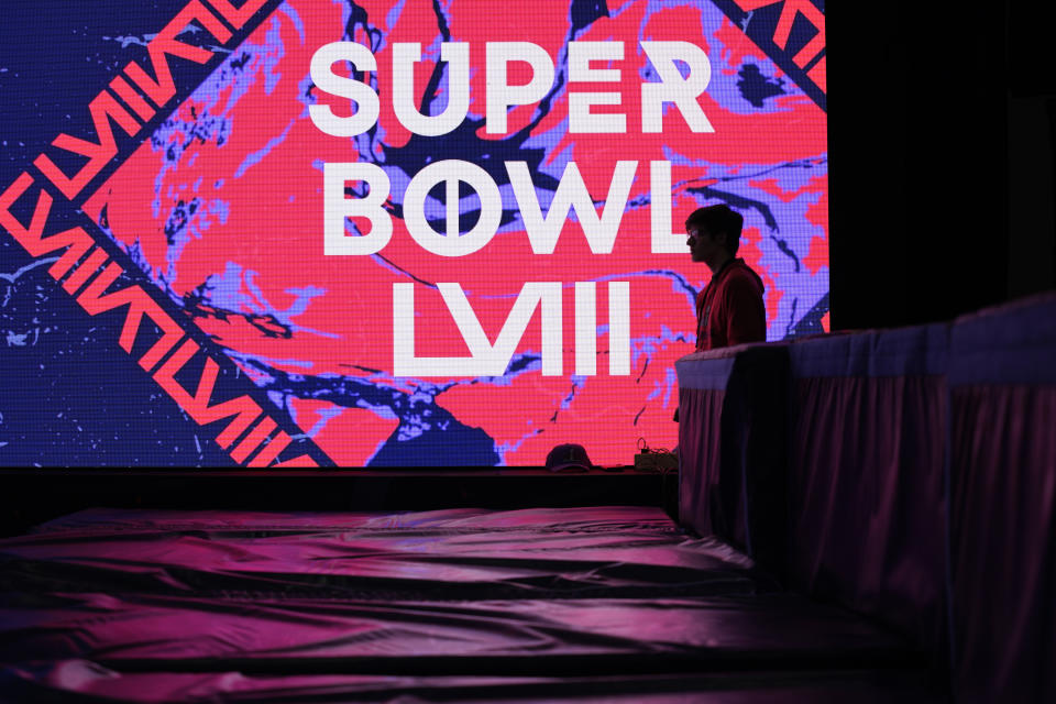 A worker stands by an exhibit at the Super Bowl Experience ahead of the Super Bowl 58 NFL football game Wednesday, Feb. 7, 2024, in Las Vegas. (AP Photo/John Locher)