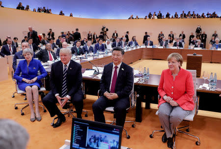 FILE PHOTO: (L-R) British Prime Minister Theresa May, US President Donald Trump, China's President Xi Jinping and German Chancellor Angela Merkel turn around for photographers at the start of the first working sessionthe G20 summit in Hamburg, Germany, July 7, 2017. Kay Nietfeld/Pool via REUTERS/File Photo