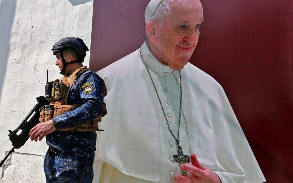 A member of the Iraqi forces stands next to a poster depicting an image of Pope Francis at the Syriac Catholic Church of Our Lady of Deliverance - Getty