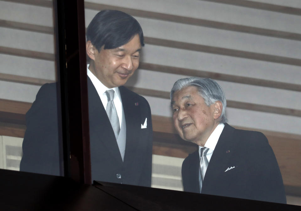 In this Sunday, Dec. 23, 2018, file photo, Japan's Emperor Akihito, right, accompanied by Crown Prince Naruhito, left, walks away after greeting well-wishers as they appear on the balcony of the Imperial Palace to mark the emperor's 85th birthday in Tokyo. (AP Photo/Eugene Hoshiko, File)