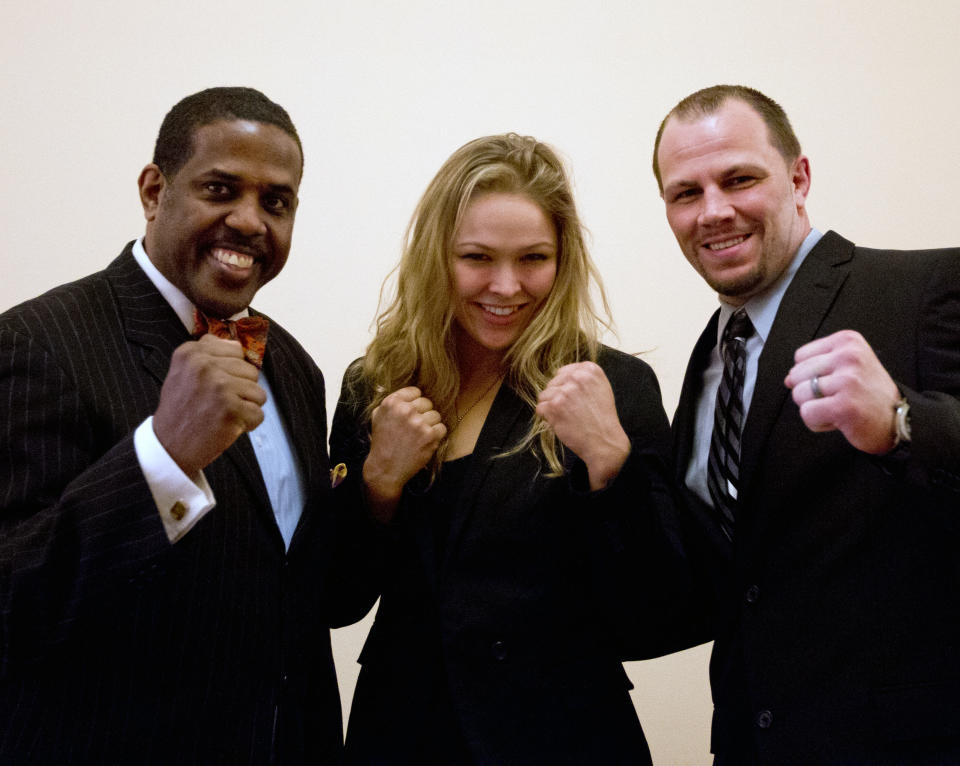 Sen. Kevin Parker, D-Brooklyn, left, poses with mixed martial arts athletes Ronda Rousey, center, and Nick Catone at the Capitol in Albany, N.Y., on Wednesday, April 18, 2012. The state Senate is expected to approve legislation again to make New York the 46th state to legalize and regulate the sport, though opposition remains in the state Assembly. (AP Photo/Mike Groll)