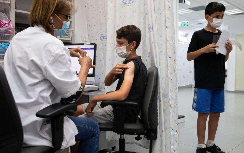 An Israeli youth receives a Pfizer-BioNTech COVID-19 vaccine in the central Israeli city of Rishon LeZion, Sunday - AP/AP