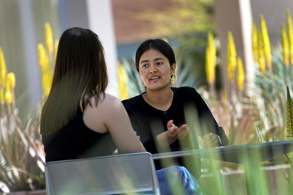 Fahima Sultani talks with a classmate at Arizona State University, Friday, April 7, 2023, in Tempe, Ariz. Sultani and others tried for days in the summer of 2021 to get into the Kabul airport, only to be turned away by the gun-wielding extremists as the Taliban swept back into power. After a harrowing escape, Sultani is one of more than 60 Afghan women who arrived at ASU in December 2021. (AP Photo/Matt York)