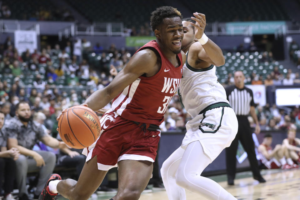 Washington State guard Kymany Houinsou (31) gets past Hawaii guard Noel Coleman during the first half of an NCAA college basketball game Friday, Dec. 23, 2022, in Honolulu. (AP Photo/Marco Garcia)