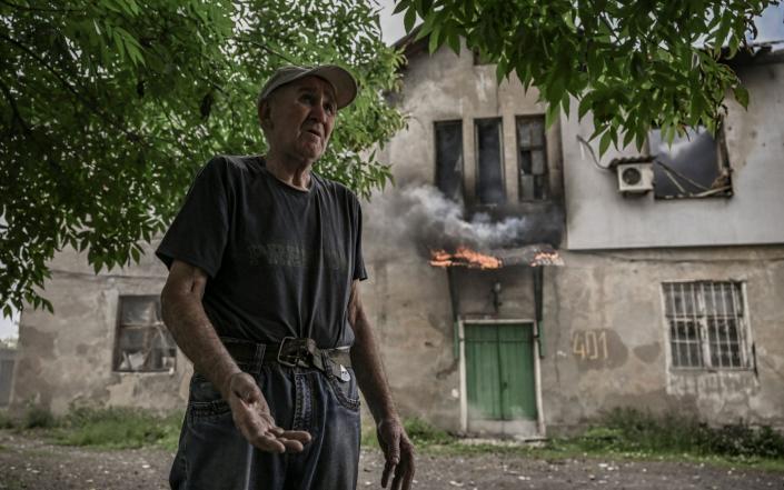 An elderly man reacts in front of his burning apartment building, which was hit by shelling, in Lysychansk, in the eastern Ukrainian region of Donbas, on June 5, 2022. - Aris Messinis/AFP