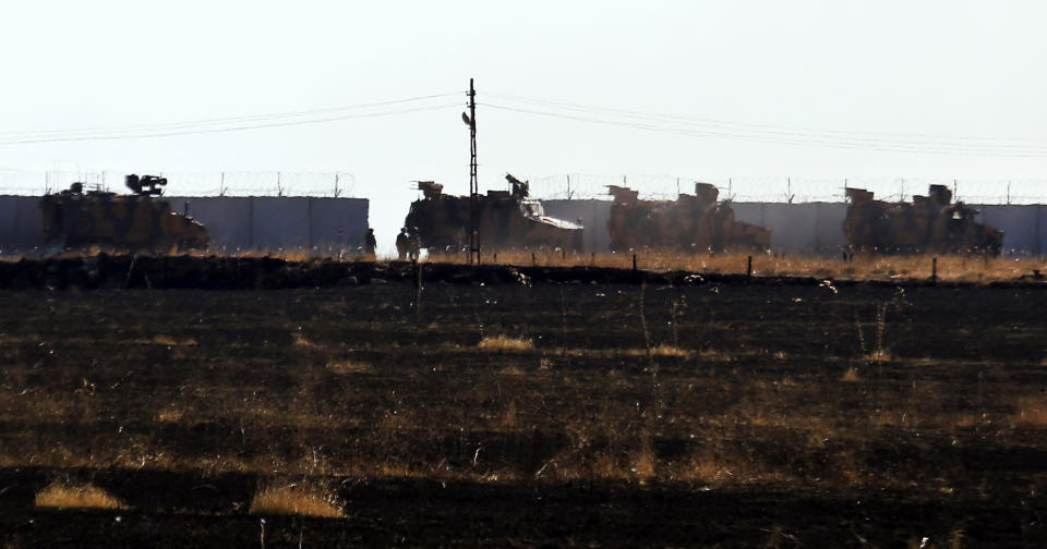 In this photo taken from the outskirts of the village of Alakamis, in Idil province, southeastern Turkey, Turkish army vehicles return to Turkey from Syria after conducting a joint patrol with Russian forces, Friday, Nov. 8, 2019. The Britain-based Syrian Observatory for Human Rights says a protester has been killed when he was run over in the village of Sarmasakh, Syria near the border by a Turkish vehicle during a joint patrol with Russia.The man was among residents who pelted with shoes and stones Turkish and Russian troops who were conducting their third joint patrol in northeastern Syria, under a cease-fire deal brokered by Moscow that forced Kurdish fighters to withdraw from areas bordering Turkey. (AP Photo/Mehmet Guzel)