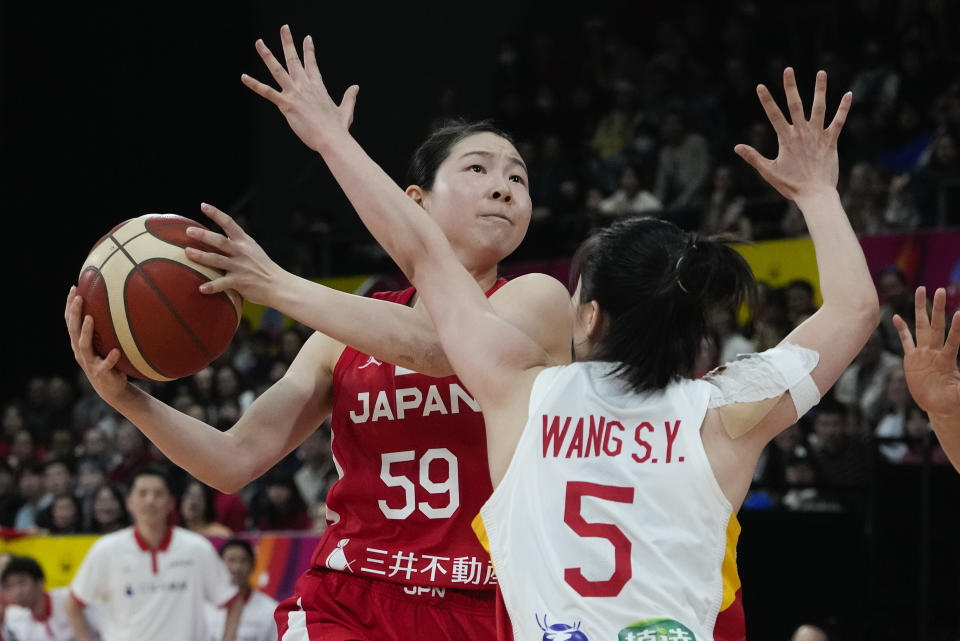 China's Wang Siyu attempts too block a shot from Japan's Anri Hoshi, left, during the Asia Cup women's basketball final in Sydney, Australia, Sunday, July 2, 2023. (AP Photo/Mark Baker)