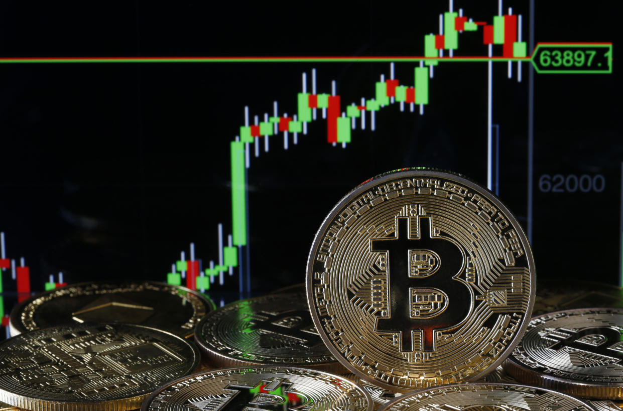 PARIS, FRANCE - APRIL 14: In this photo illustration, a visual representation of the digital Cryptocurrency, Bitcoin is on display in front of the Bitcoin course's graph on April 14, 2021 in Paris, France. The value of Bitcoin (BTC) has exceeded the threshold of 64,000 dollars for the first time in history. The Cryptocurrency overtakes the British Pound to become the 6th largest currency in the world. The total bitcoin market now represents $ 1.2 trillion, while that of all cryptocurrencies stands at $ 2251 billion. (Photo illustration by Chesnot/Getty Images)