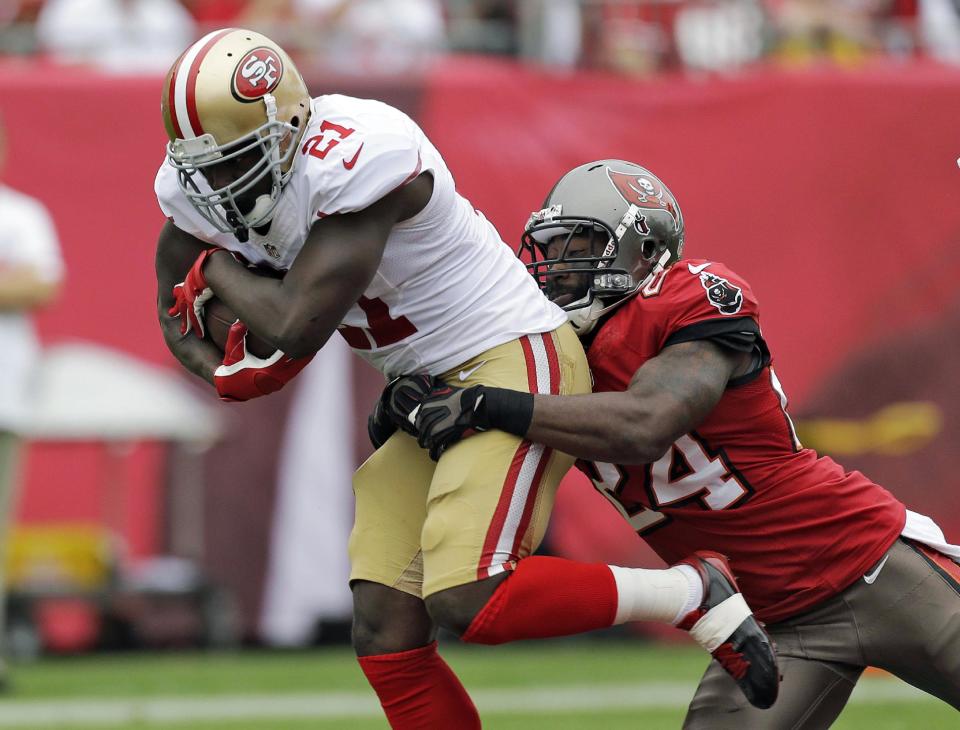 FILE - In this Dec. 15, 2013, file photo, San Francisco 49ers running back Frank Gore (21) is grabbed by Tampa Bay Buccaneers cornerback Darrelle Revis (24) during the first quarter of an NFL football game in Tampa, Fla. The Buccaneers have parted ways with Revis, releasing the five-time Pro Bowl cornerback Wednesday, March 12, 2014, after being unable to trade him and his $16 million annual salary. (AP Photo/Chris O'Meara, File)