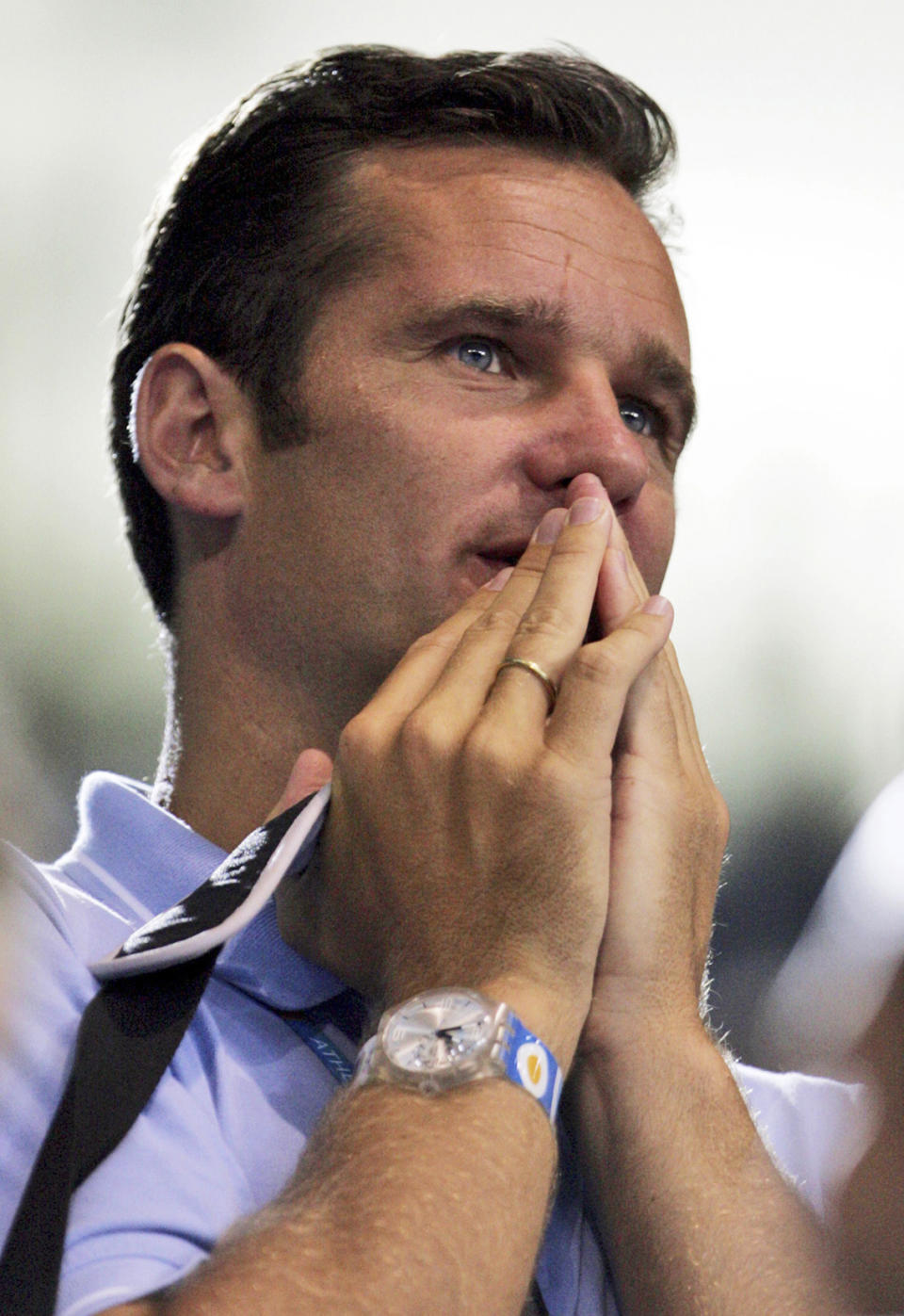 FILE - In this Aug. 20, 2004 file photo Spain's Duke of Palma Inaki Urdangarin and husband of Spain's Princess Cristina reacts while watching a handball match in Athens. Urdangarin, the Spanish king's son-in-law and husband of Princess Cristina will undergo interrogation over alleged corruption Saturday Feb. 25, 2012 in Palma de Mallorca. Although the case file against him remains sealed, much has been leaked and Urdangarin is suspected of using his high-profile position to win contracts from regional governments for a non-profit foundation he ran, then subcontract the work to for-profit companies he also ran, sometimes charging the governments ridiculously inflated prices and stashing at least some of the income in overseas tax havens. The king has dropped Urdangarin like a hot potato, announcing in December his son-in-law would no longer take part in official ceremonies with the rest of the family. (AP Photo/Andrew Medichini, File)