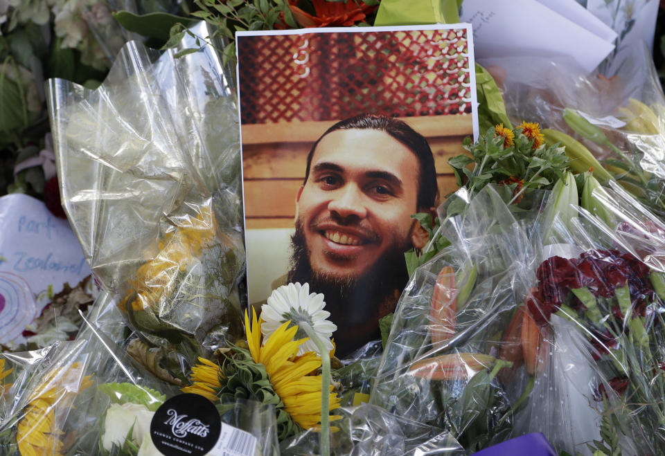 A photo tribute for Christchurch mosque shooting victim Tariq Omar lies amid mounds of flowers across the road from the Al Noor mosque in Christchurch, New Zealand Tuesday, March 19, 2019. (AP Photo/Mark Baker)